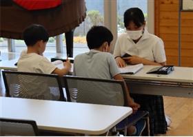 習字や宿題に取り組んでいる小学生を見守っている様子2枚目