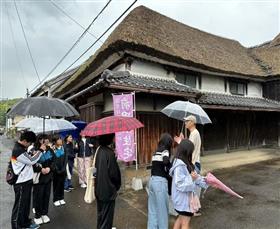 国登録文化財である前田家住宅前をキセキ部員に案内する岩楯顧問